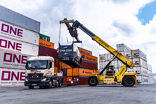 Ein Reachstacker stetzt ein Flat auf die Zugmaschine von Addicks & Kreye.