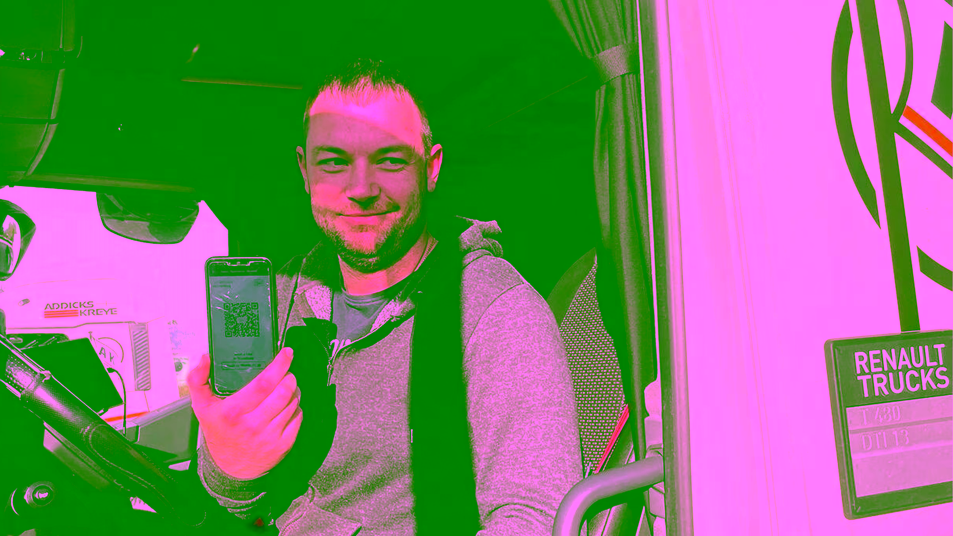 LKW Fahrer im LKW zeigt ein Handy mit einer der neuen Apps